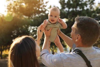 Parents with their cute baby in park on sunny day