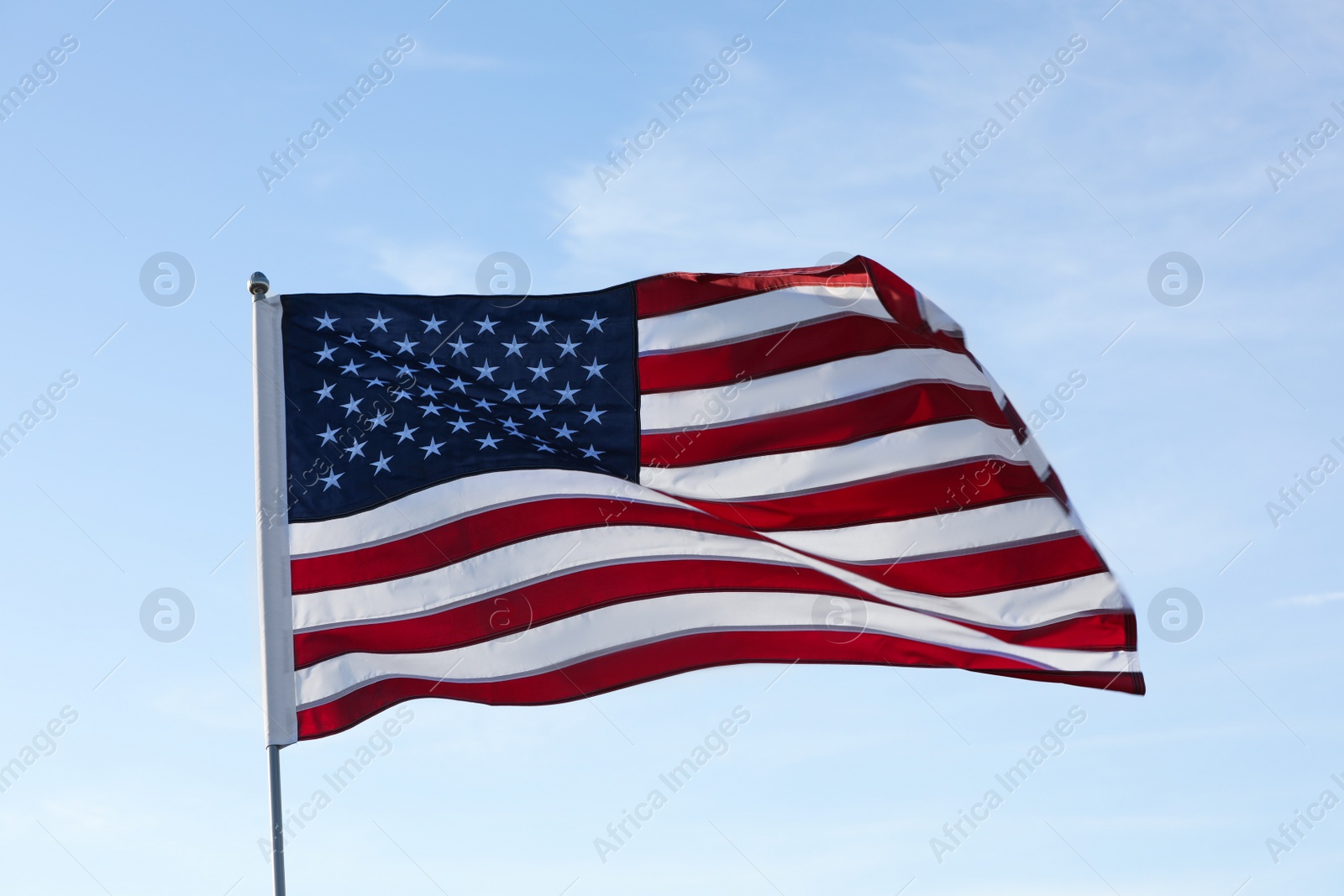 Photo of American flag fluttering outdoors on sunny day