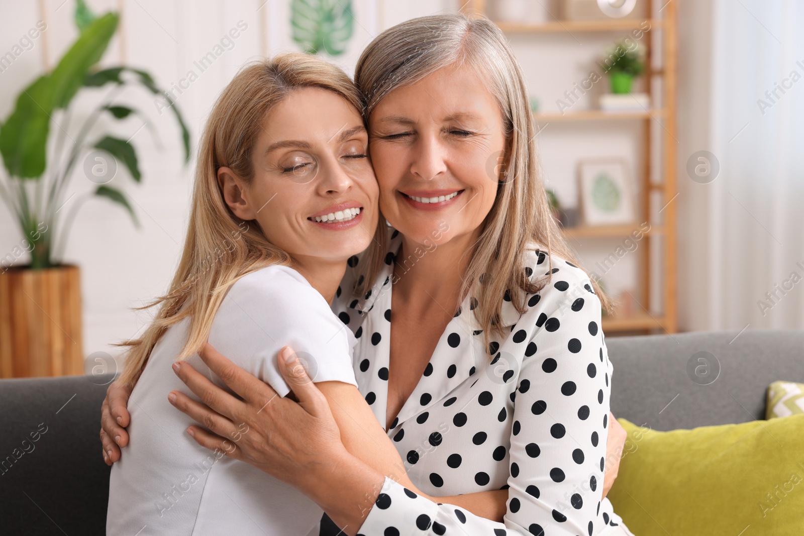 Photo of Happy mature mother and her daughter hugging at home