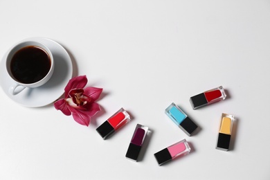 Photo of Composition with nail polishes and coffee on white background, top view