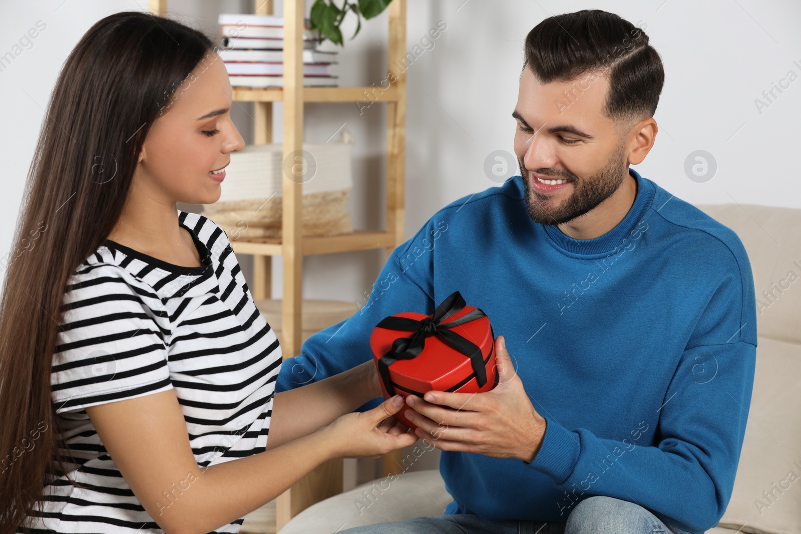 Photo of Lovely couple with beautiful gift at home