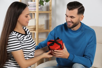 Photo of Lovely couple with beautiful gift at home