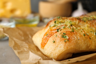 Photo of Tasty homemade garlic bread with cheese and herbs on table, closeup. Space for text