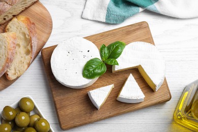 Photo of Flat lay composition with tasty brie cheese on white wooden table