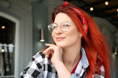 Photo of Young woman with bright dyed long hair outdoors