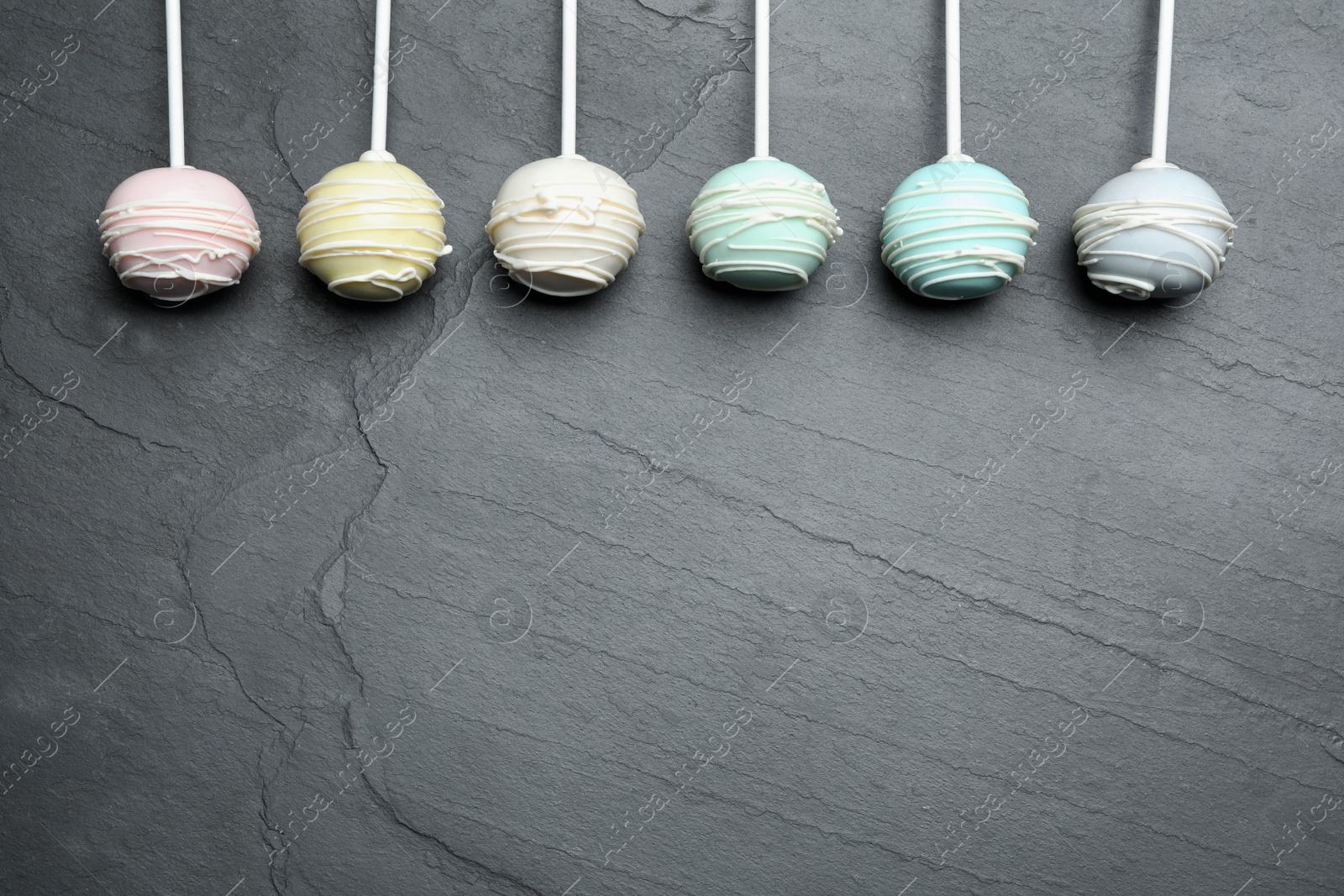 Photo of Sweet cake pops on grey background, flat lay. Space for text