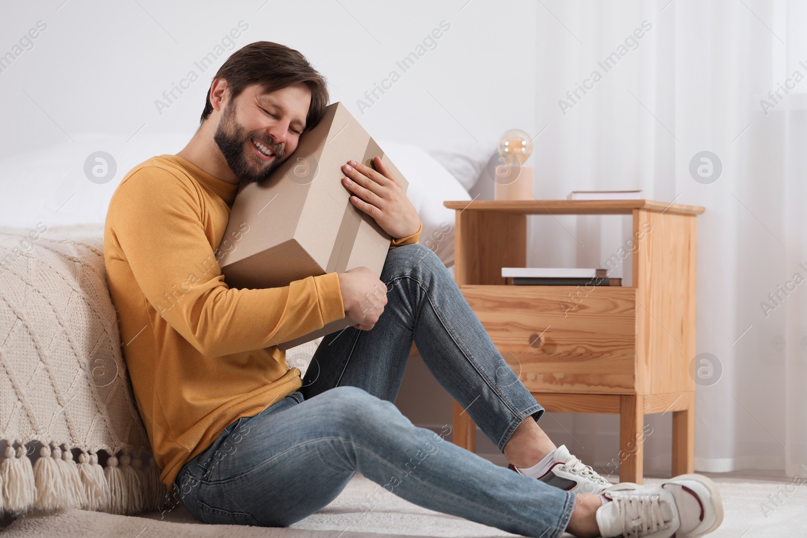 Photo of Happy man with parcel at home. Internet shopping