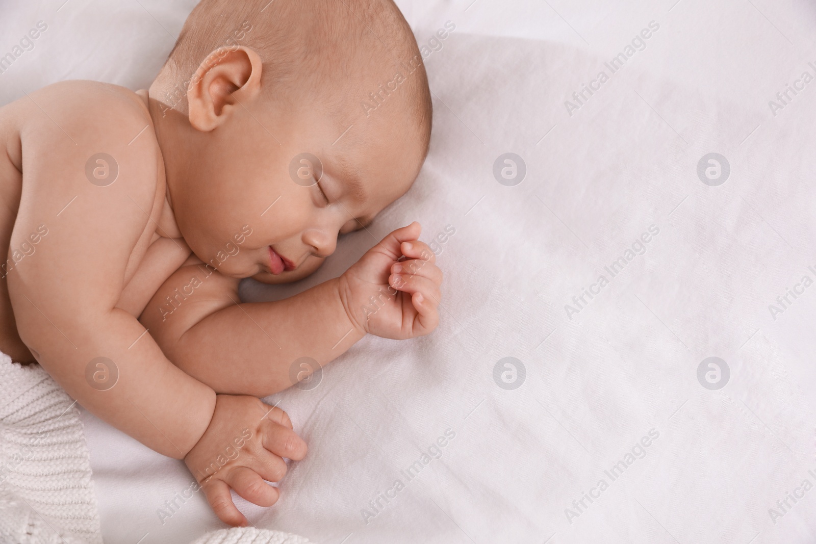 Photo of Cute little baby sleeping in bed, top view. Space for text