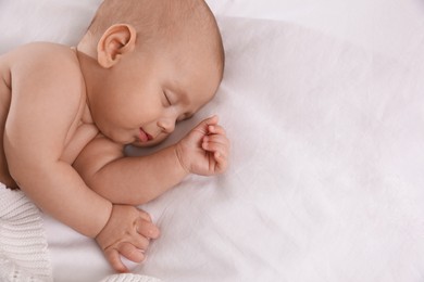 Photo of Cute little baby sleeping in bed, top view. Space for text