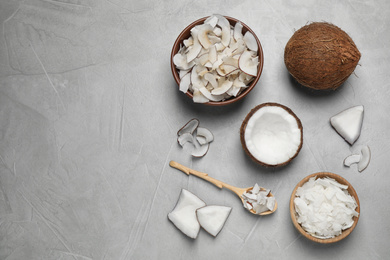 Photo of Flat lay composition with tasty coconut chips on grey table. Space for text