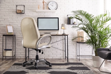 Photo of Comfortable chair near desk in modern office interior