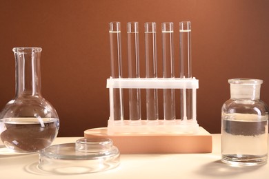 Laboratory analysis. Different glassware on table against brown background