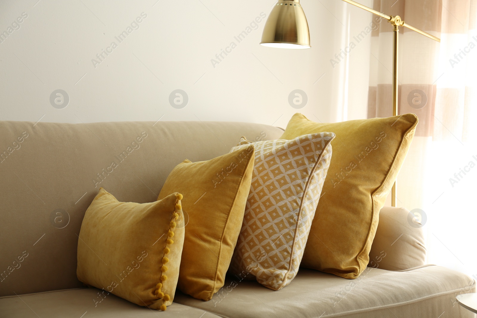 Image of Three pillows on sofa near wall in room. Interior design