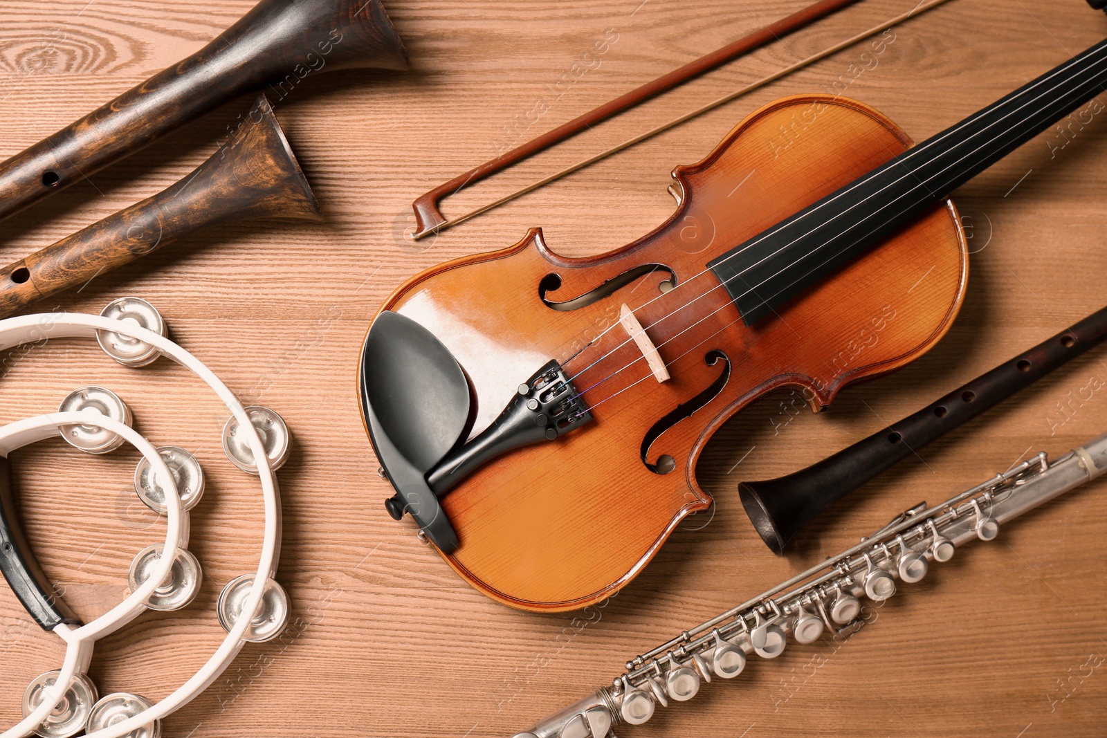 Photo of Set of different musical instruments on wooden background, flat lay