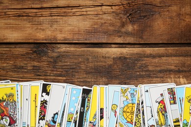 Tarot cards on wooden table, top view. Space for text