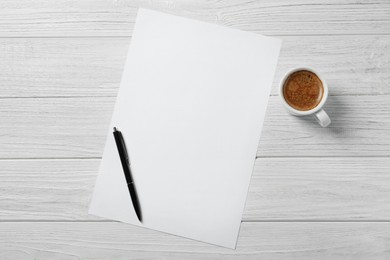 Blank paper sheet, pen and cup of coffee on white wooden table, flat lay. Space for text