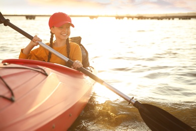 Photo of Happy girl kayaking on river. Summer camp activity