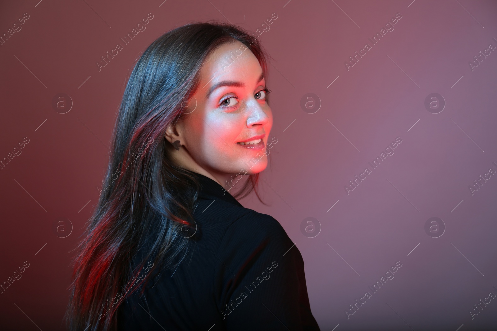 Photo of Portrait of beautiful young woman on color background with neon lights