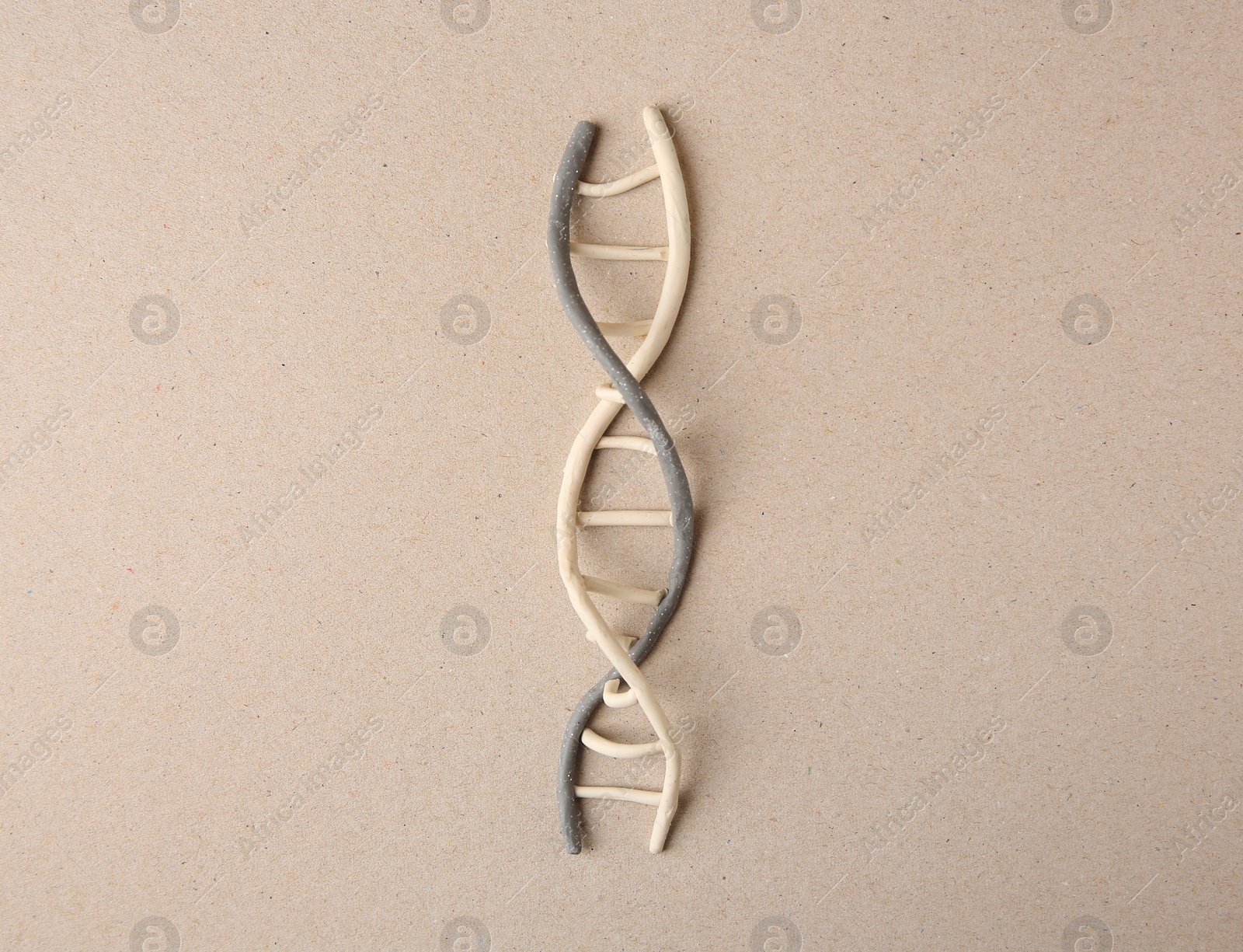 Photo of Plasticine model of DNA molecular chain on beige background, top view