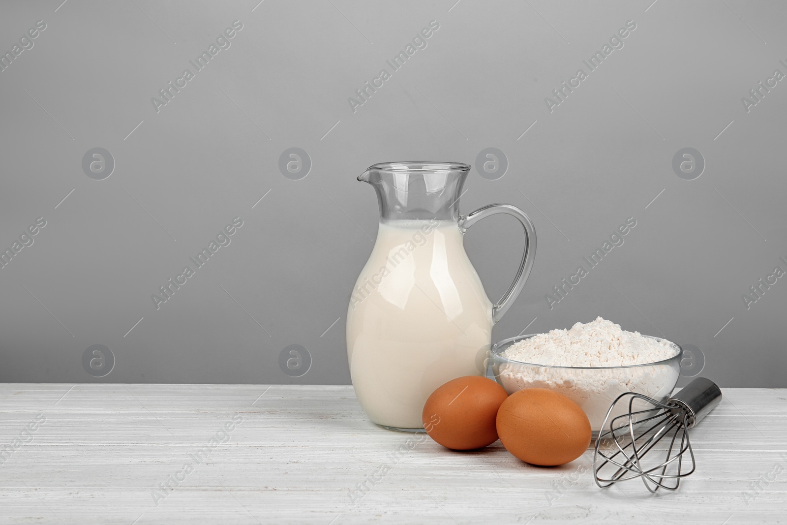 Photo of Raw eggs and other ingredients on white wooden table, space for text. Baking pie