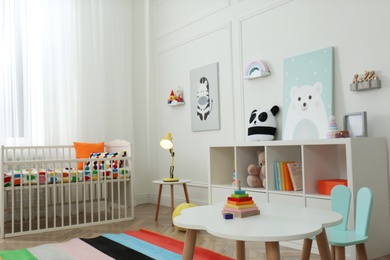 Photo of Cute baby room interior with stylish furniture and toys