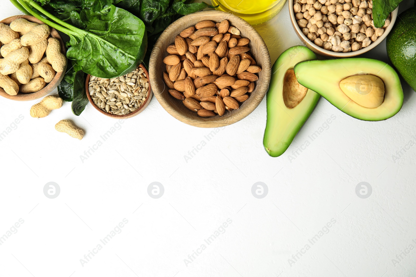 Photo of Different products rich in Vitamin E on white background, flat lay. Space for text