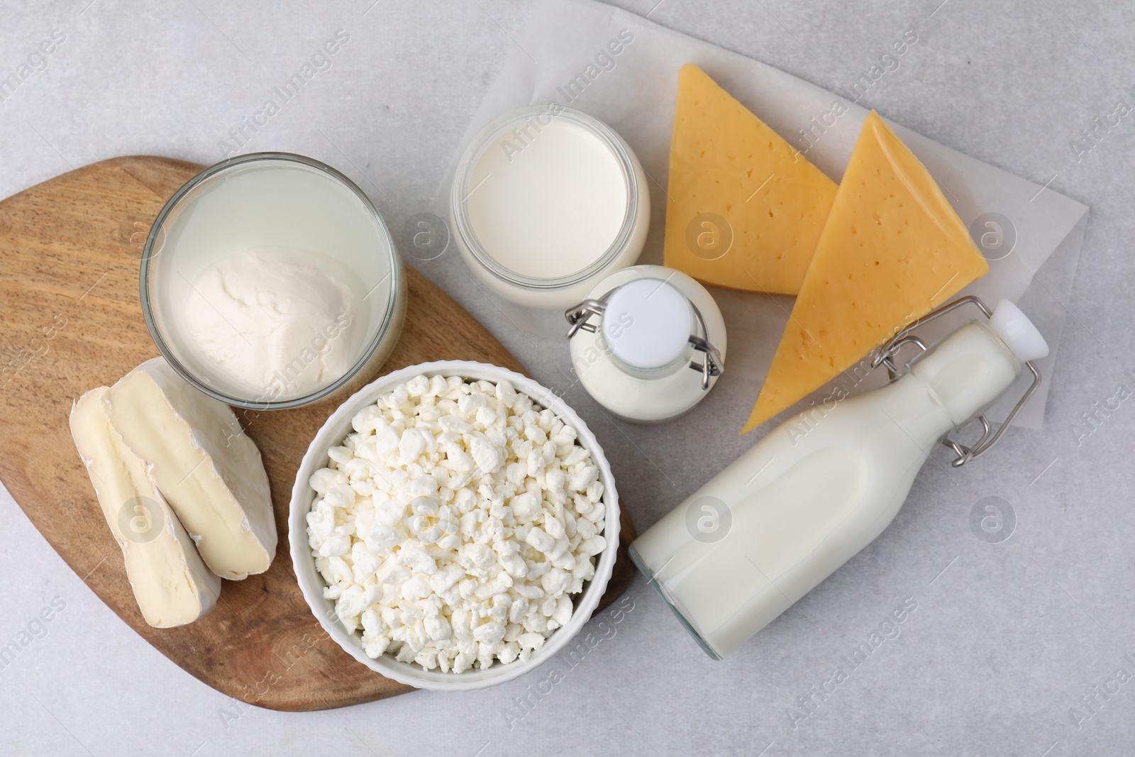 Photo of Different fresh dairy products on light table, flat lay