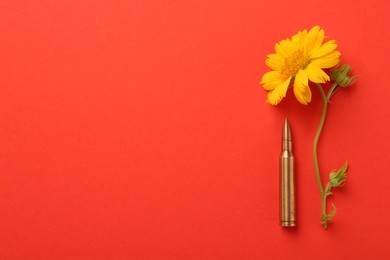 Bullet and beautiful flower on red background, flat lay. Space for text