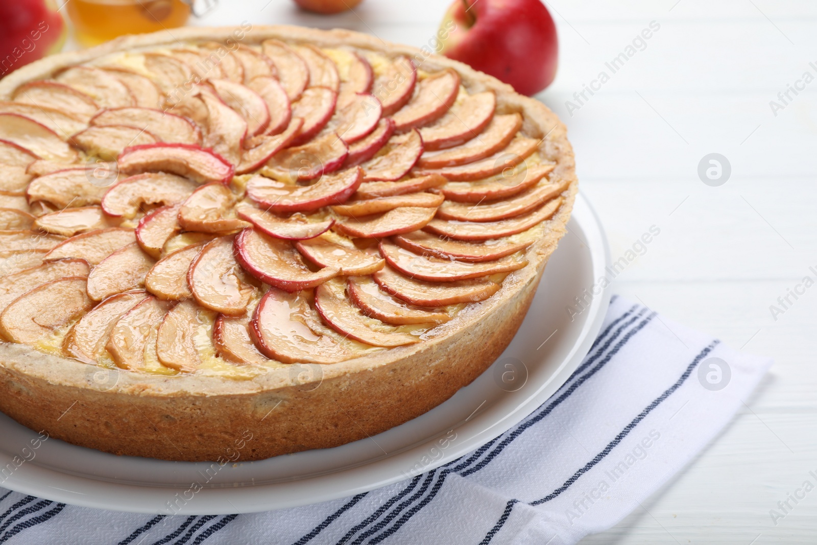 Photo of Tasty apple pie on white wooden table, closeup