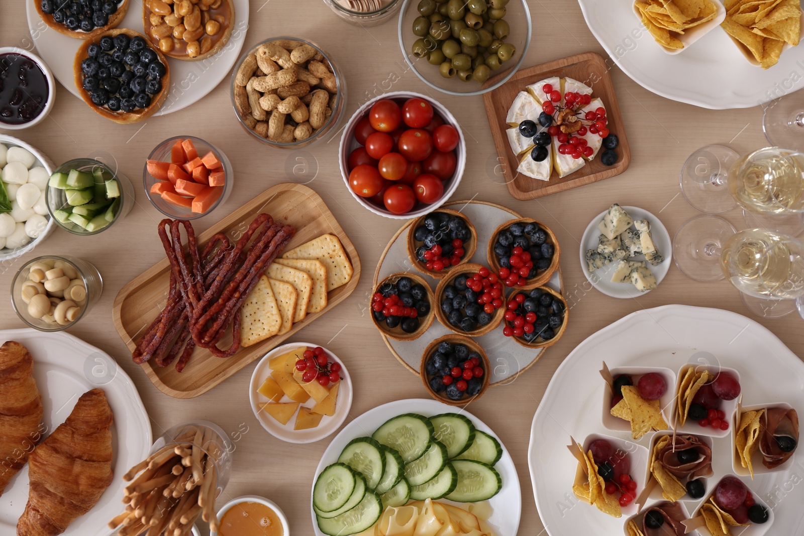 Photo of Variety of snacks on wooden table in buffet style, flat lay