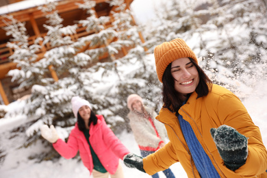 Photo of Group of friends playing snowballs outdoors. Winter vacation