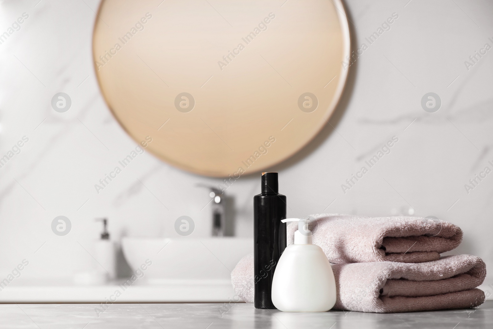 Photo of Folded towels and toiletries on marble table in bathroom, space for text