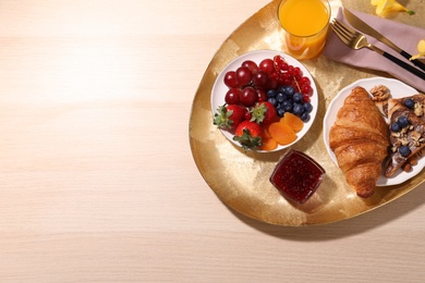 Delicious breakfast with croissant on wooden table, top view. Space for text