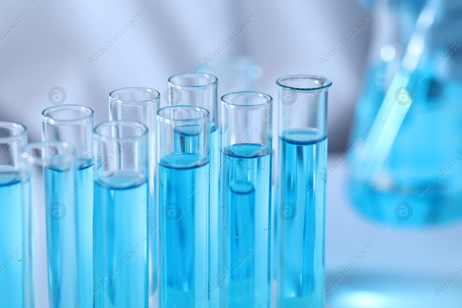 Photo of Test tubes with light blue liquid in laboratory, closeup