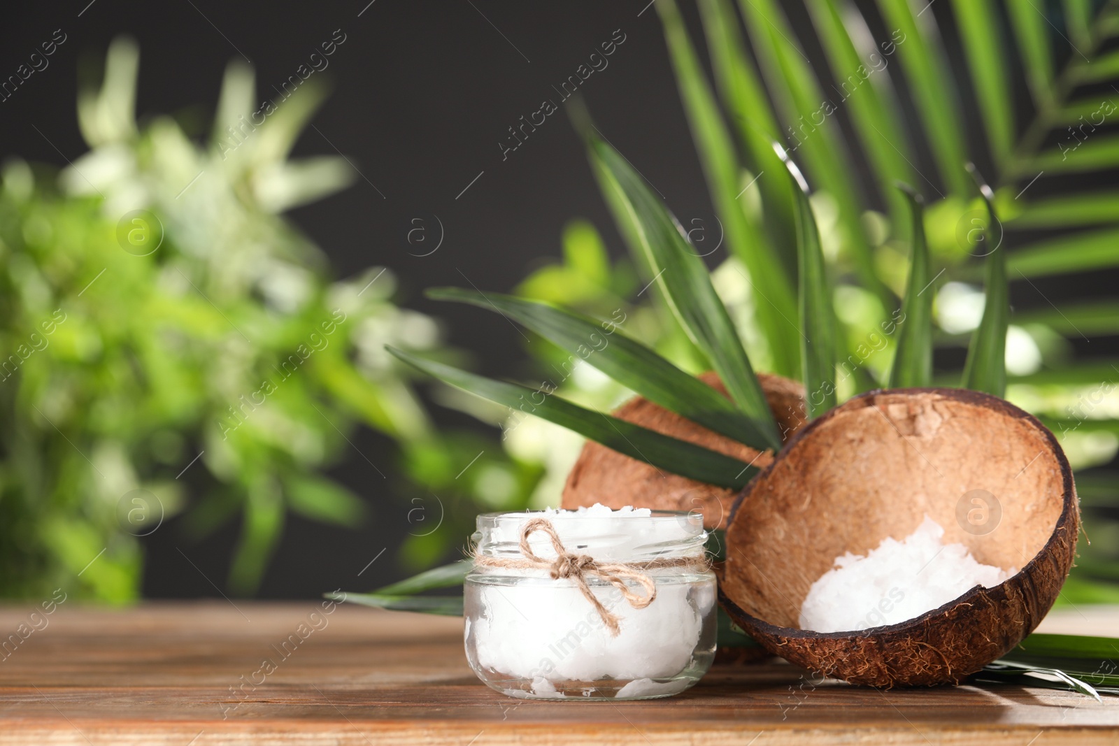 Photo of Composition with natural organic coconut oil on wooden table. Space for text