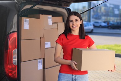 Courier with parcel near delivery van outdoors, space for text