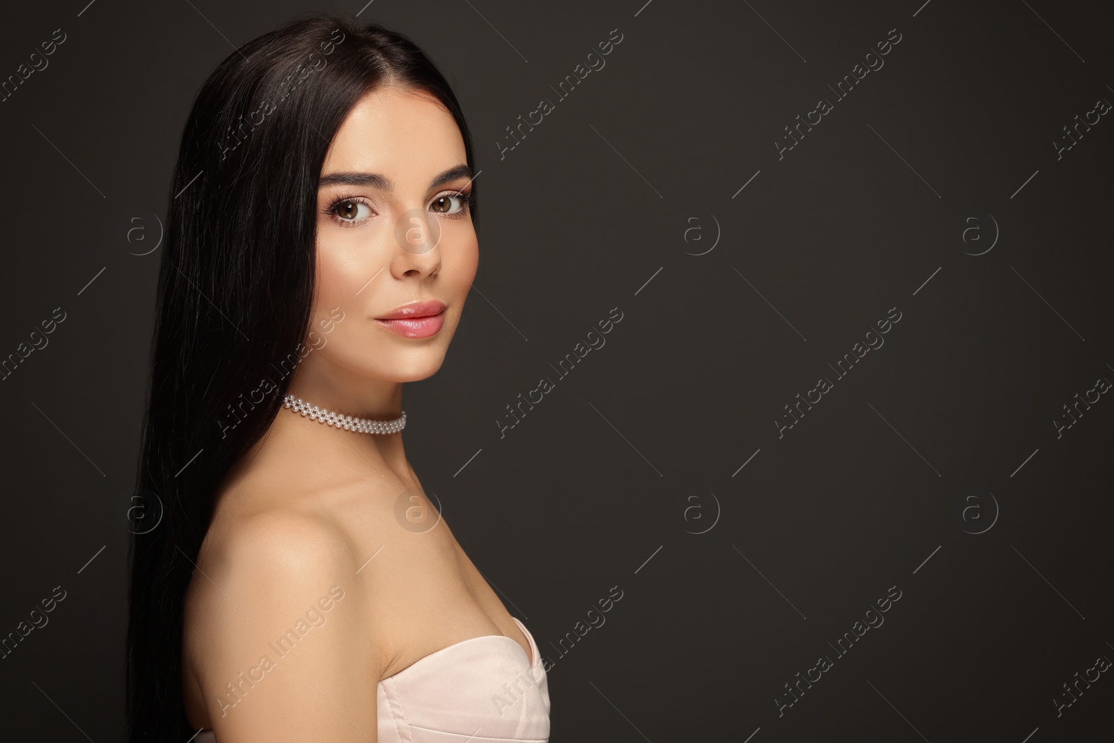 Photo of Young woman with beautiful makeup on black background. Space for text