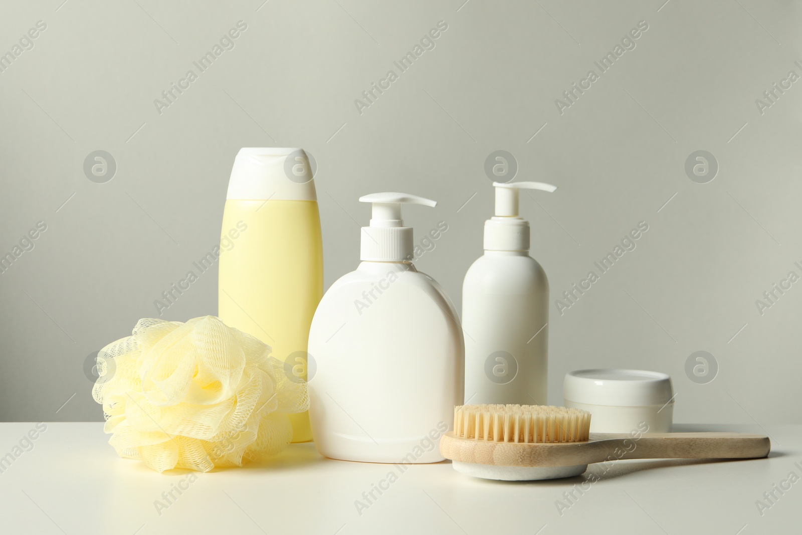 Photo of Different bath accessories on white table against grey background