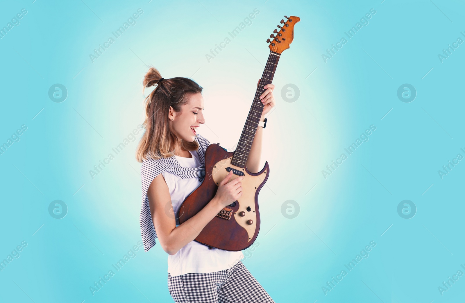 Photo of Young woman playing electric guitar on color background. Space for text
