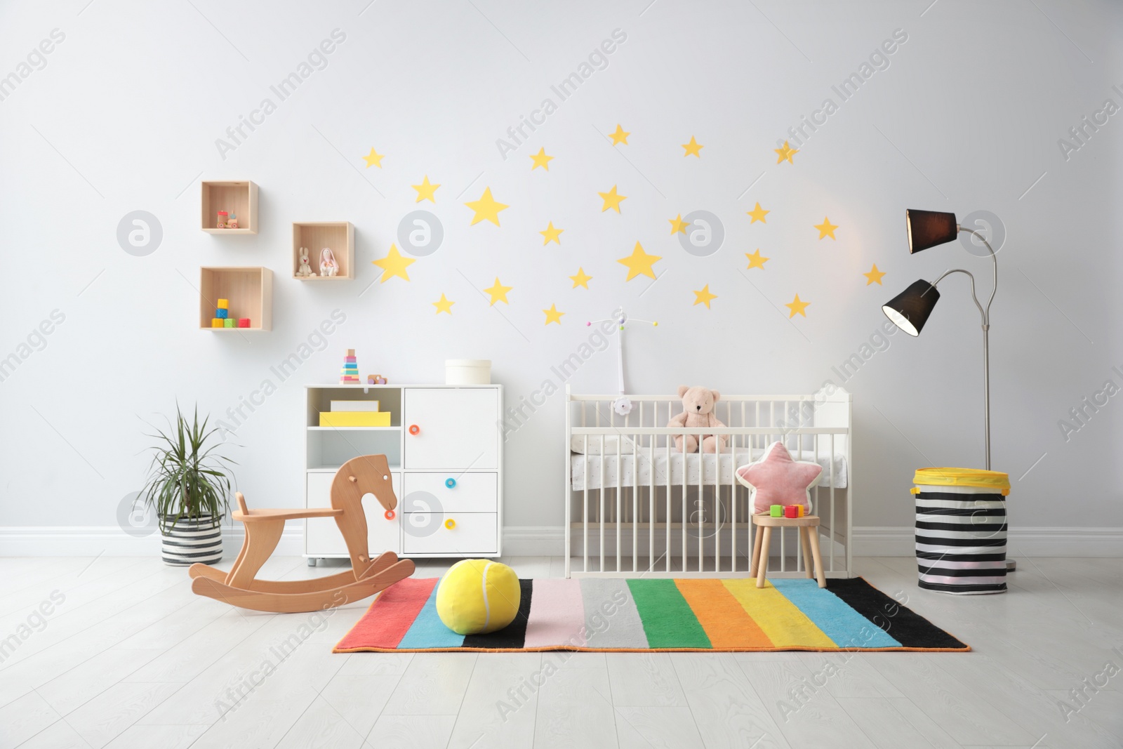 Photo of Stylish baby room interior with crib and toys