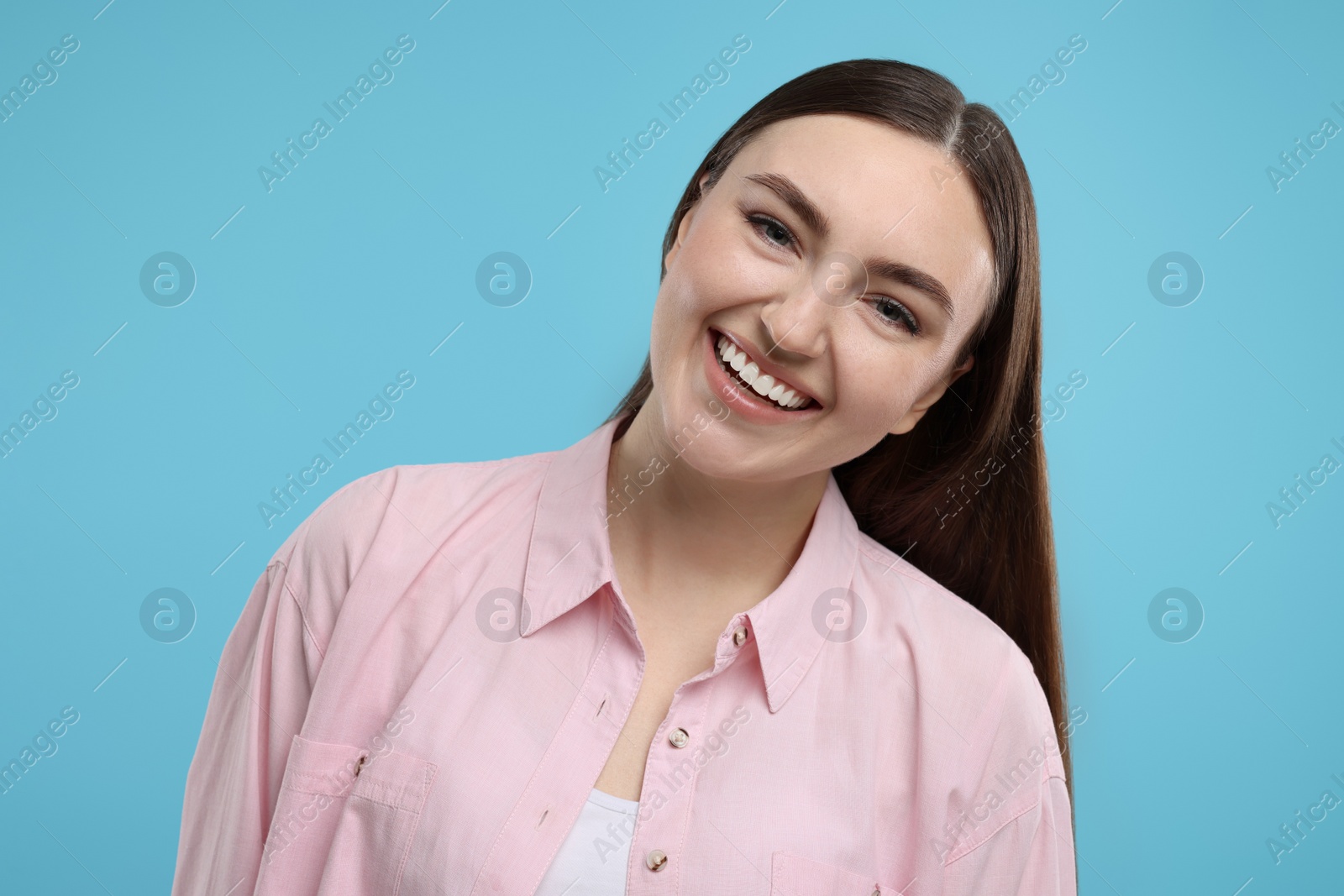 Photo of Portrait of beautiful woman laughing on light blue background