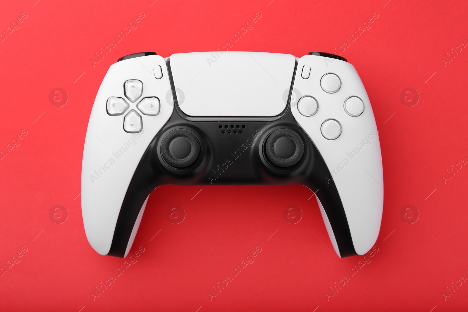 Photo of Wireless game controller on red background, top view