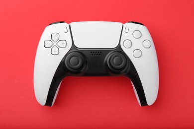 Photo of Wireless game controller on red background, top view