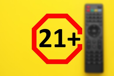 Image of Age limit sign 21+ years and blurred view of remote control on yellow background
