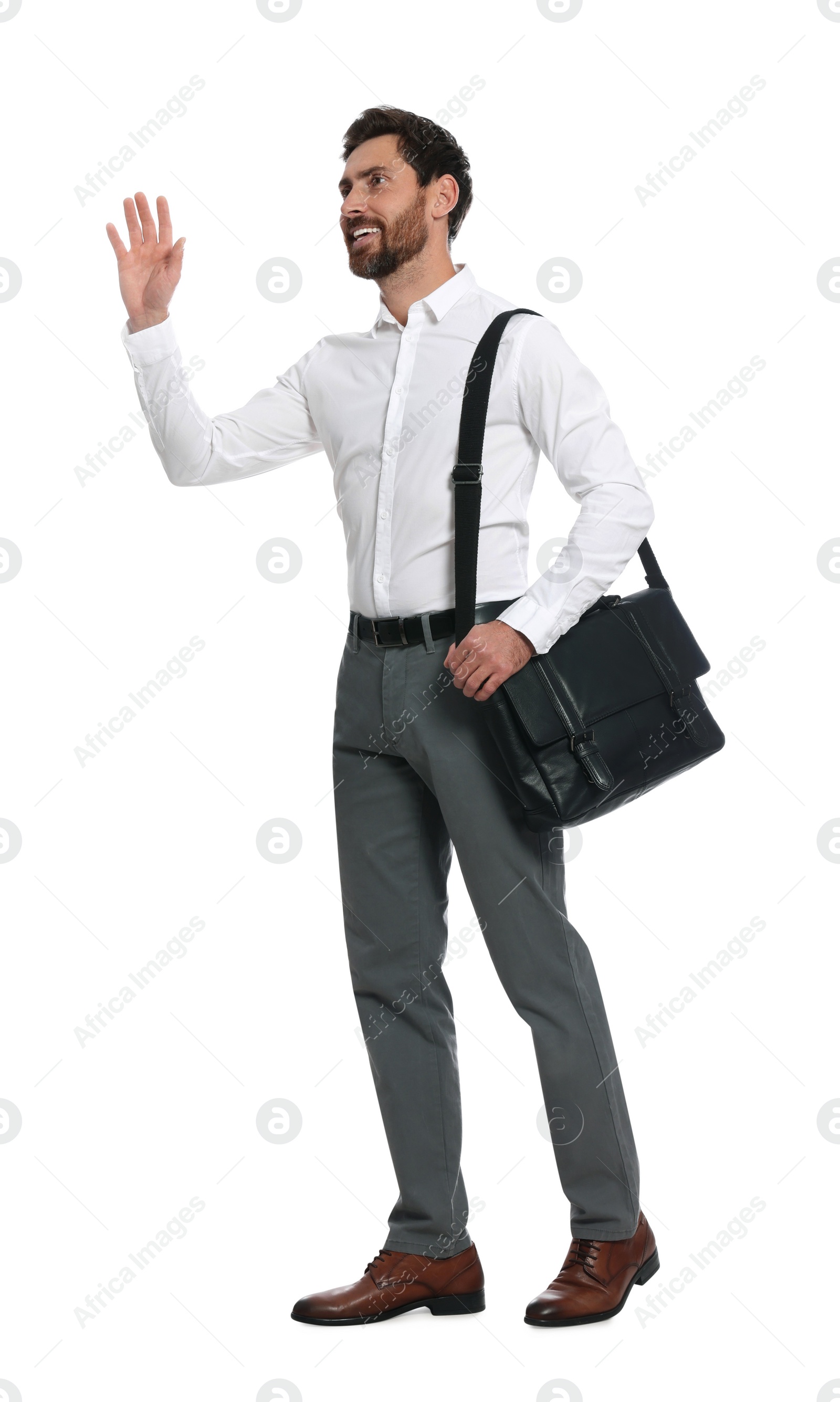 Photo of Handsome man with black bag waving to say hello while walking on white background