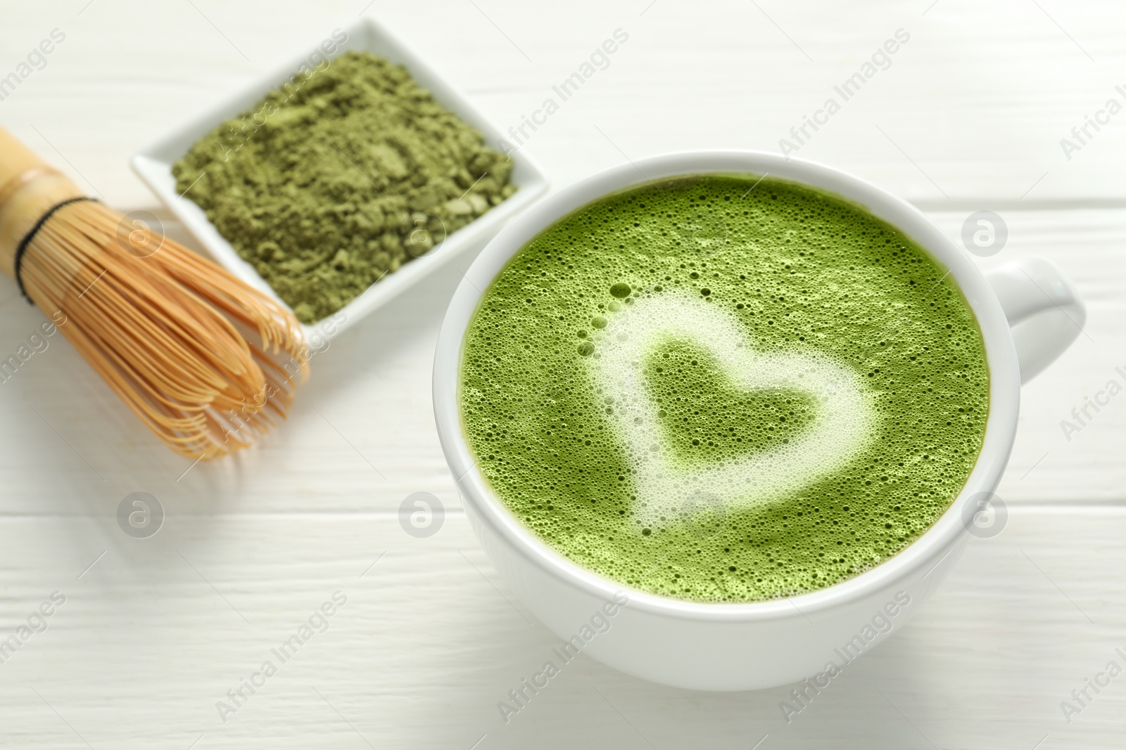 Photo of Cup of fresh matcha latte on white wooden table, closeup