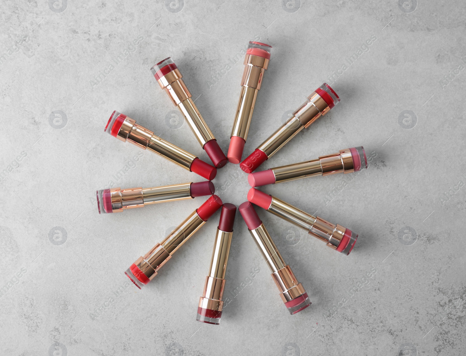 Photo of Set of bright lipsticks on grey background, flat lay