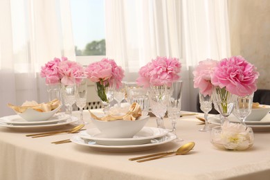 Photo of Stylish table setting with beautiful peonies and fabric napkins indoors