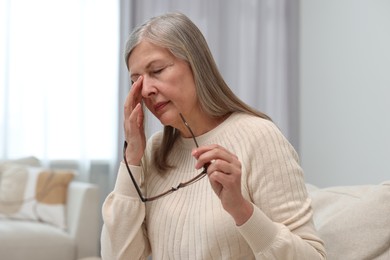 Overwhelmed woman with glasses suffering at home