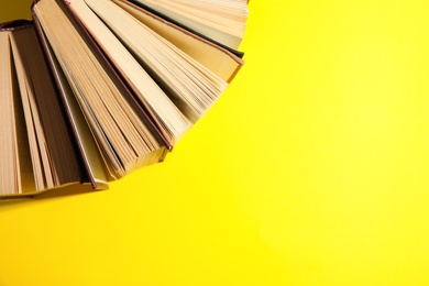 Hardcover books on yellow background, flat lay. Space for text
